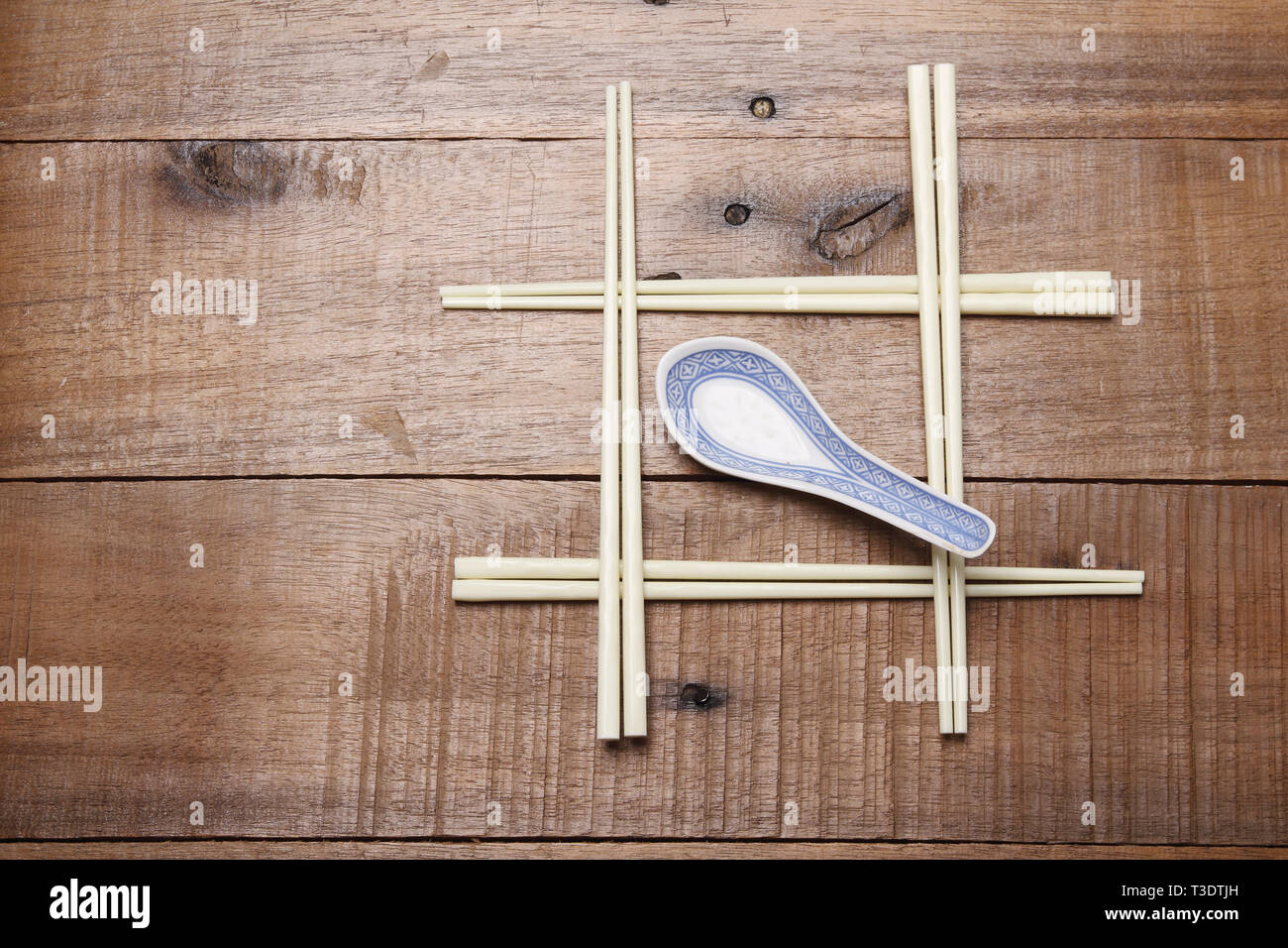 Bacchette e Mestolo su sfondo di legno Foto Stock