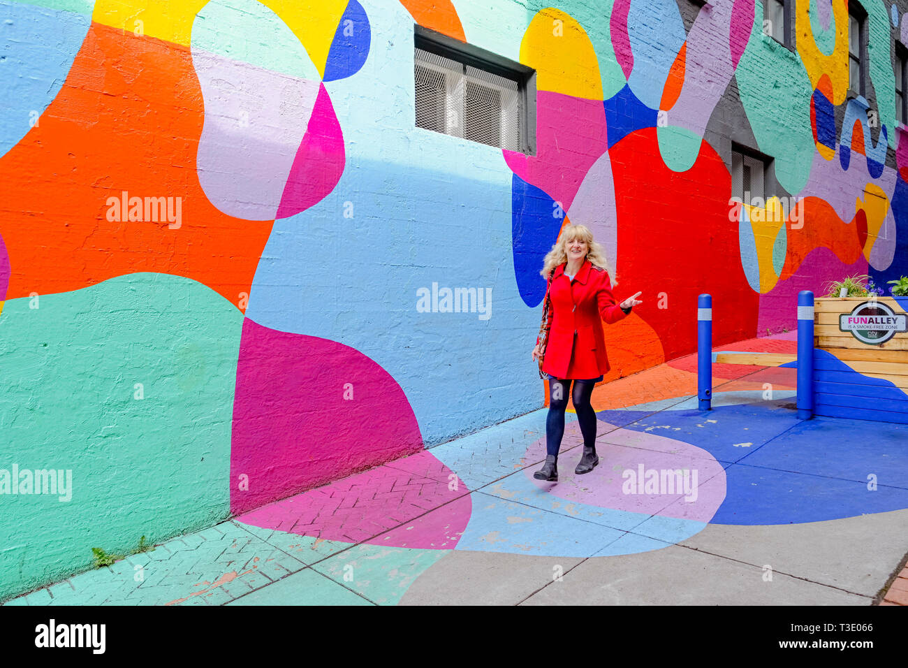 La donna a piedi attraverso il divertimento Alley, inferiore Lonsdale area, North Vancouver, British Columbia, Canada Foto Stock