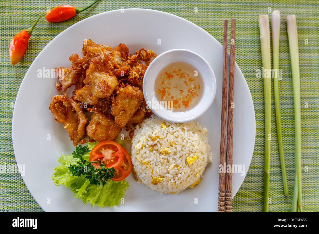 Tradizionale vietnamita di maiale fritto tritare con la citronella servito con salsa di pomodoro e riso fritto con uova. Bacchette di legno sul lato. Vista dall'alto. Foto Stock
