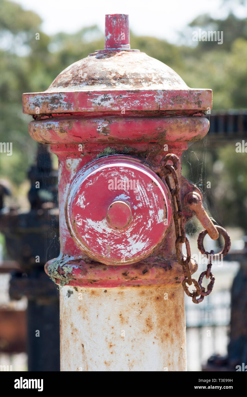 La porzione superiore di un vecchio rosso smantellata idrante di fuoco in stretta verso l'alto. Foto Stock