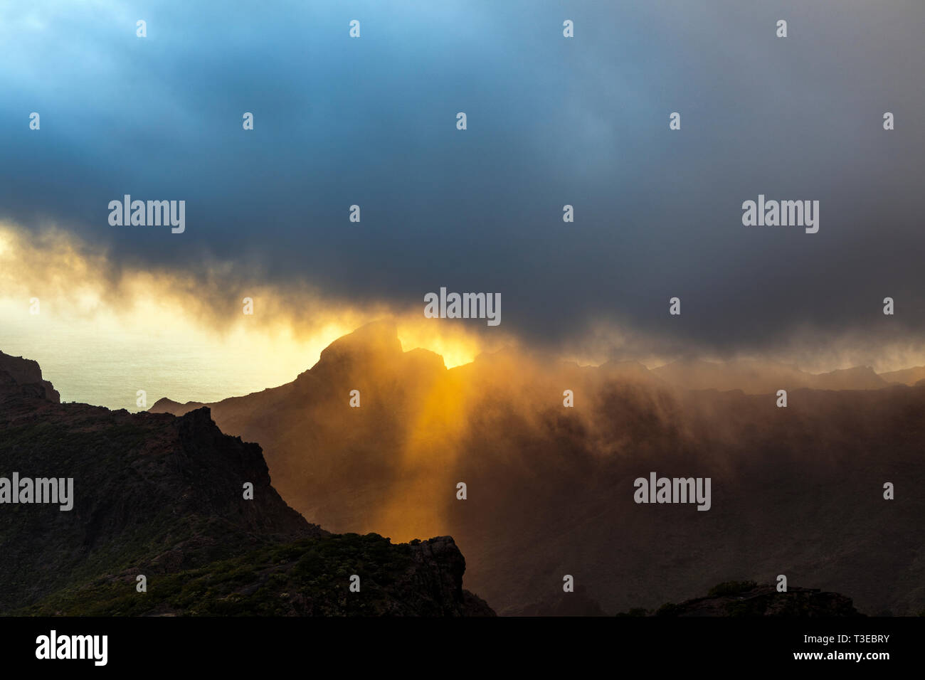 Rainclouds soffiando attraverso il cielo con i raggi di luce in tarda giornata appena prima del tramonto del Teno Masif come si vede dal Degollada del Cherfe, Mas Foto Stock