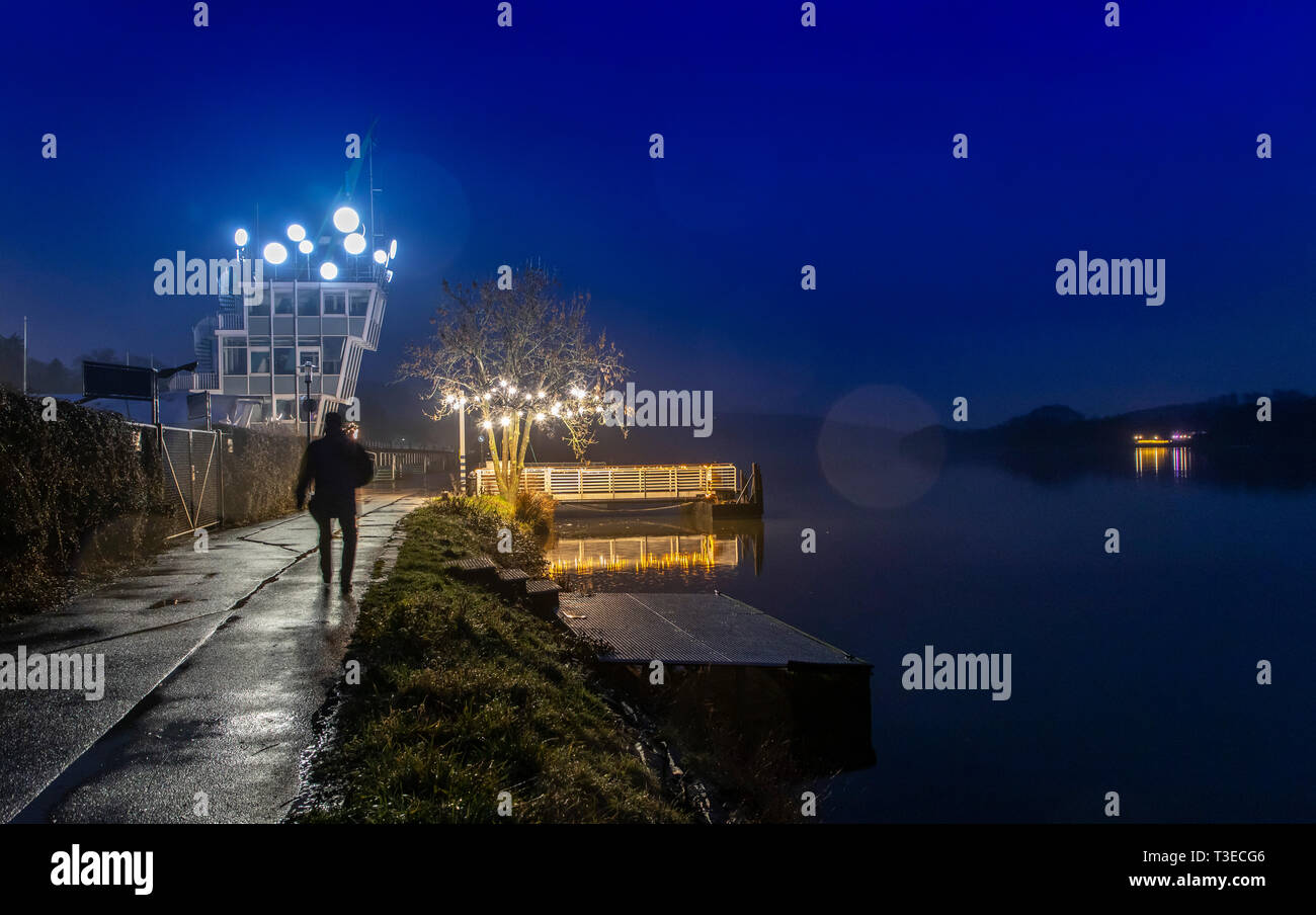 Il Baldeneysee di Essen, in Germania, in inverno, pioggia, regata di torre con orologio opera d'arte 'tempo', in serata, Foto Stock