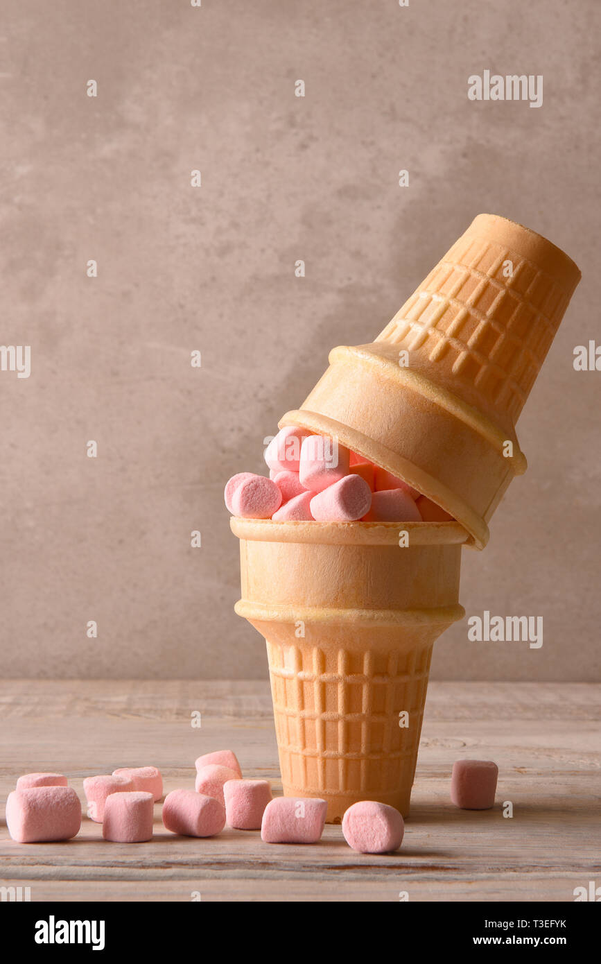 Due coni gelato con rosa marshmallows uno sulla parte superiore o altri fthe, formato verticale con copia spazio. Foto Stock