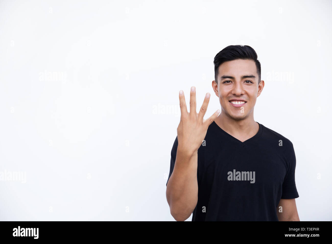Bello il latino uomo ispanico è che mostra quattro dita isolato su sfondo bianco. Posto per testo e design. Foto Stock