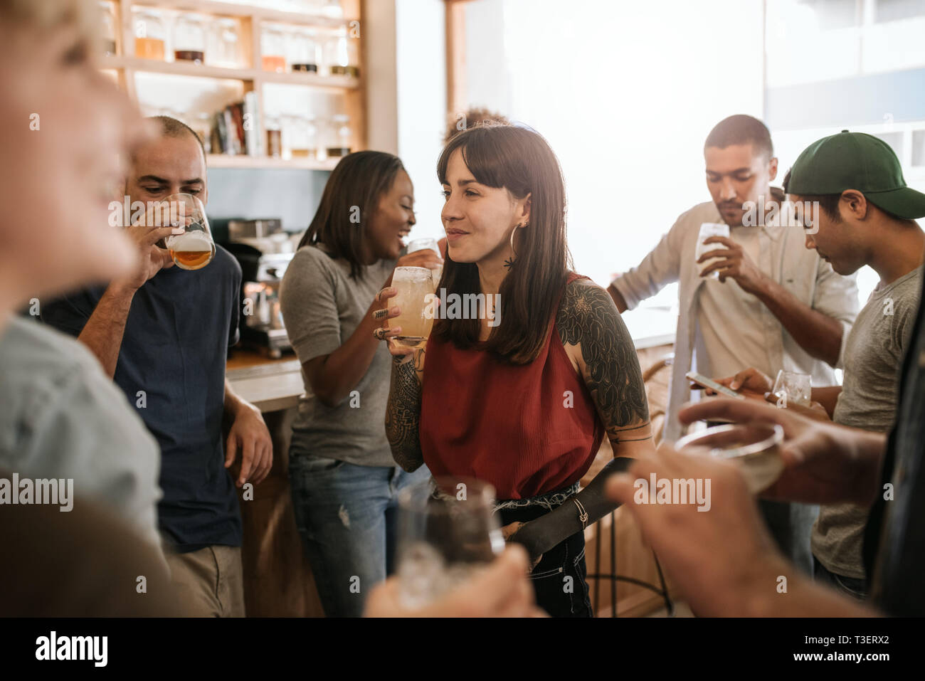 Sorridente giovane donna appendere fuori con gli amici in un bar Foto Stock