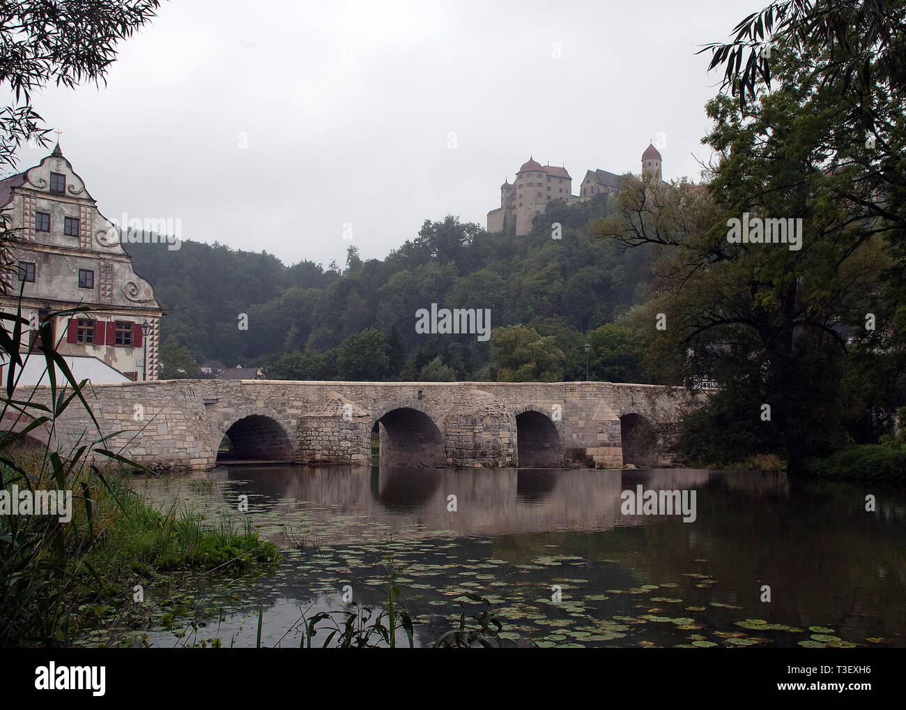 Harburg in Germania, in vista del ponte sul fiume Wornitz con castello in sfondo nebbioso Foto Stock