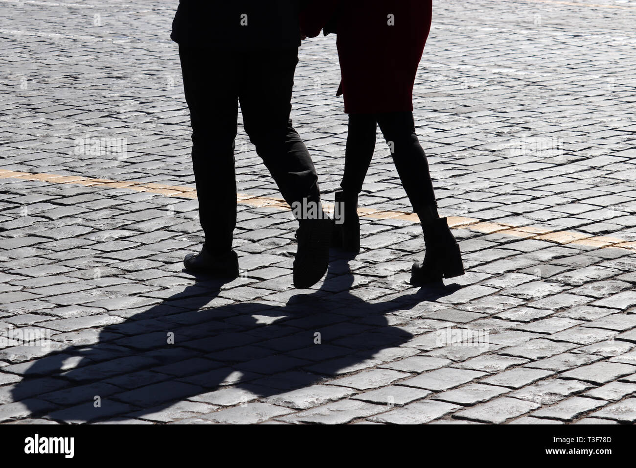 Silhouette di amore giovane sulla strada, ombre sul marciapiede. Due persone che camminano all'aperto, un concetto per amore romantico, famiglia, rapporti Foto Stock
