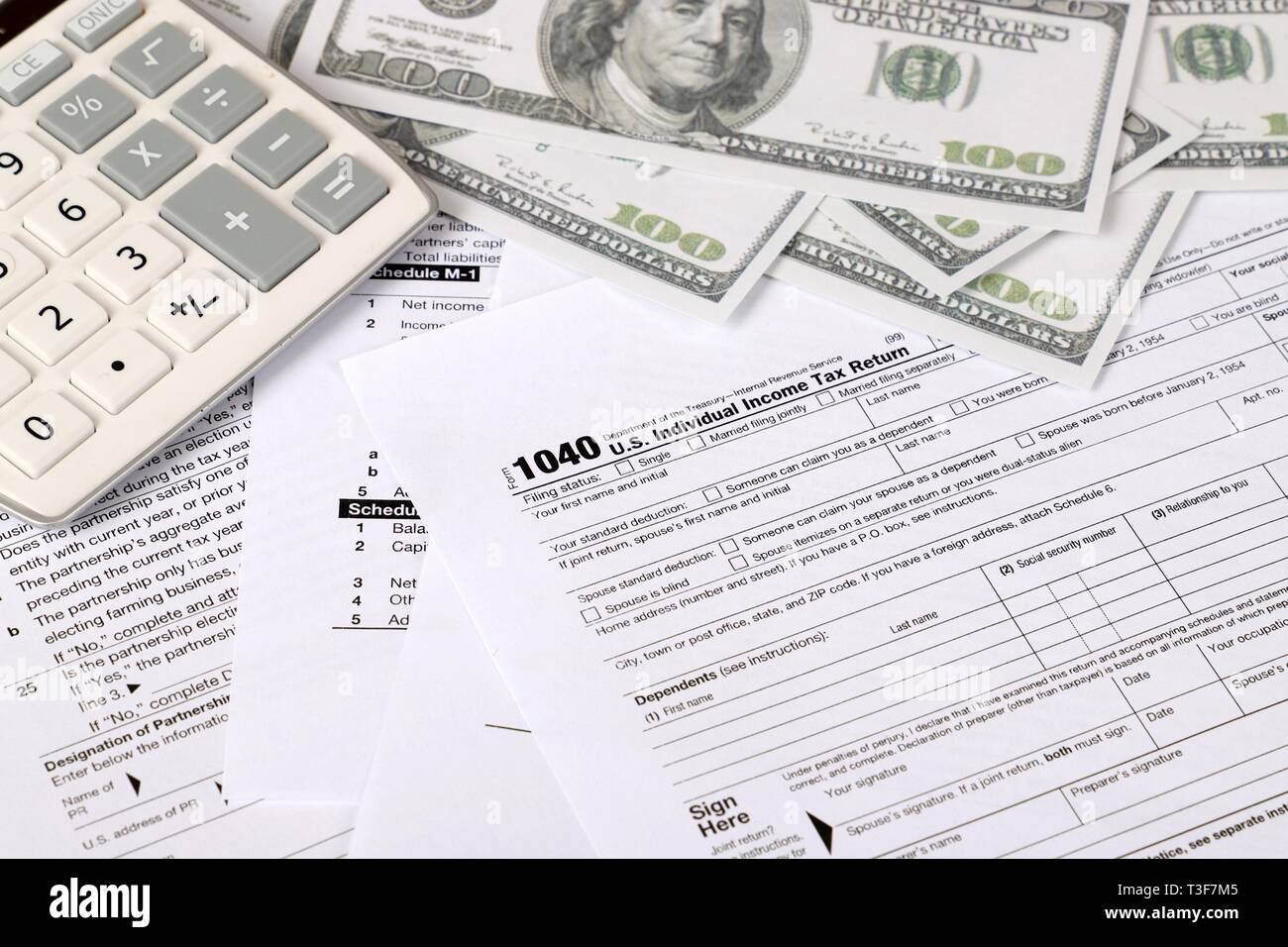 1040 forma fiscale - i singoli redditi forma 1040 si trova nei pressi di centinaia di fatture del dollaro e la calcolatrice su un tavolo Foto Stock