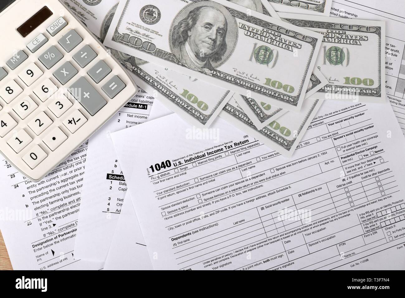 1040 forma fiscale - i singoli redditi forma 1040 si trova nei pressi di centinaia di fatture del dollaro e la calcolatrice su un tavolo Foto Stock