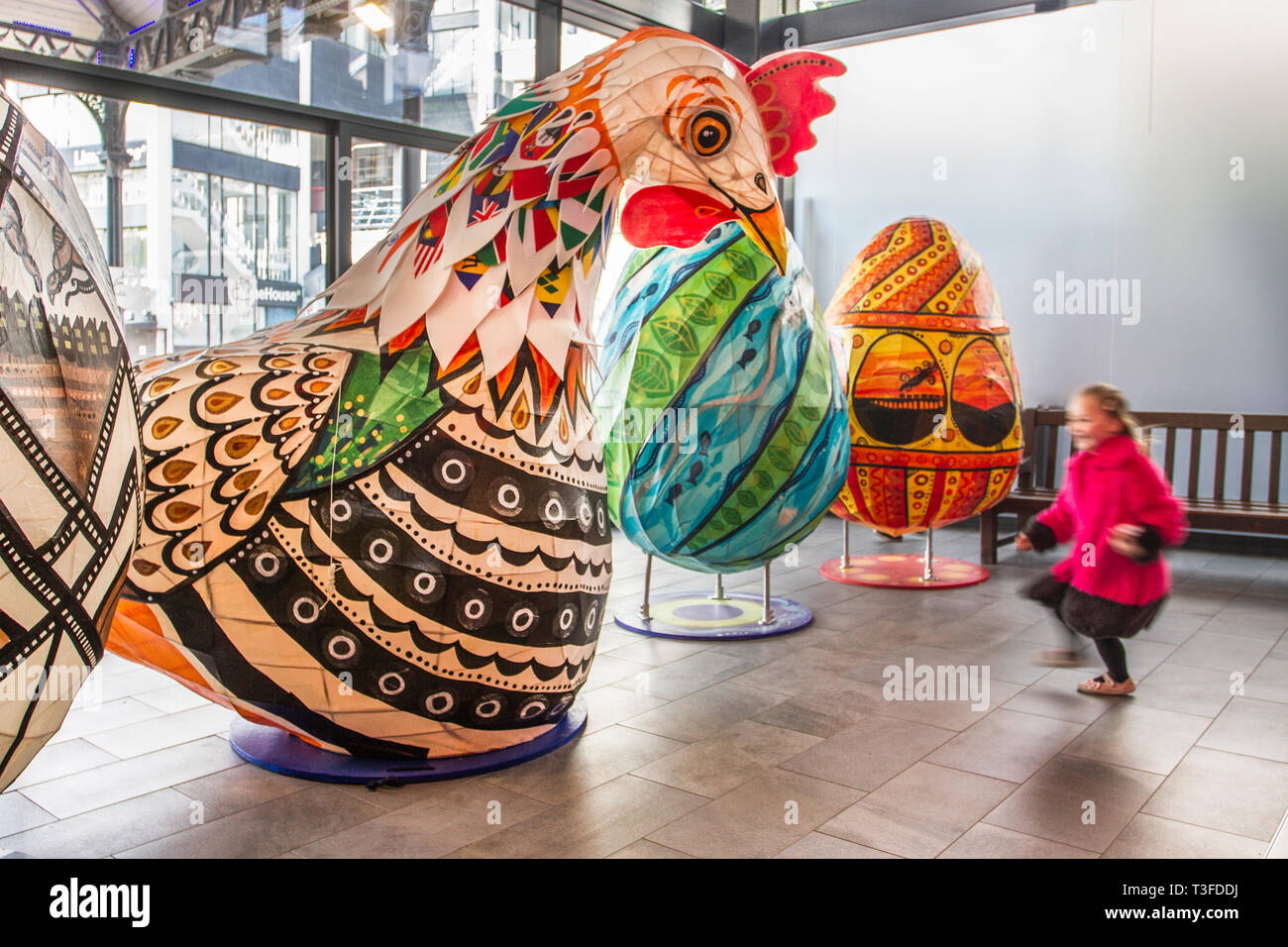I polli giganti di Pasqua Papier-Mache sono esposti nel centro di Preston. Debbie di Leyland è incuriosito dal gigantesco cockerel. Figure festive di Pasqua in mostra, tanding a due metri di altezza, le grandi attrazioni animali devono essere collocati fuori Preston Market. Keith Ogden, un artista locale, è l'uomo dietro l'attrazione dipinta a mano. Le uova sono a tema intorno al patrimonio industriale della città e paesaggi Lancashire. I mercati di Preston espongono le uova di Pasqua giganti per la competizione di selfie durante le vacanze di Pasqua. Foto Stock