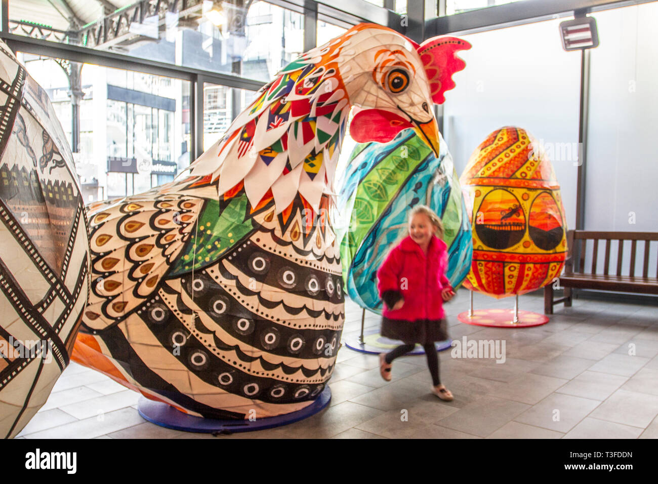 I polli giganti di Pasqua Papier-Mache sono esposti nel centro di Preston. Debbie di Leyland è incuriosito dal gigantesco cockerel. Figure festive di Pasqua in mostra, tanding a due metri di altezza, le grandi attrazioni animali devono essere collocati fuori Preston Market. Keith Ogden, un artista locale, è l'uomo dietro l'attrazione dipinta a mano. Le uova sono a tema intorno al patrimonio industriale della città e paesaggi Lancashire. I mercati di Preston espongono le uova di Pasqua giganti per la competizione di selfie durante le vacanze di Pasqua. Foto Stock