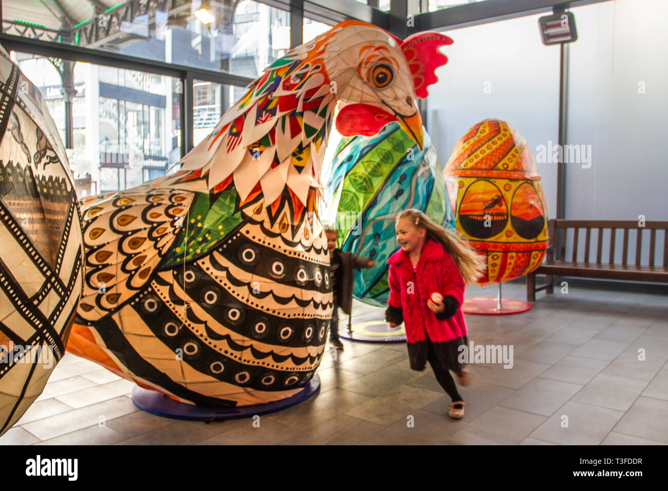 I polli giganti di Pasqua Papier-Mache sono esposti nel centro di Preston. Debbie di Leyland è incuriosito dal gigantesco cockerel. Figure festive di Pasqua in mostra, tanding a due metri di altezza, le grandi attrazioni animali devono essere collocati fuori Preston Market. Keith Ogden, un artista locale, è l'uomo dietro l'attrazione dipinta a mano. Le uova sono a tema intorno al patrimonio industriale della città e paesaggi Lancashire. I mercati di Preston espongono le uova di Pasqua giganti per la competizione di selfie durante le vacanze di Pasqua. Foto Stock