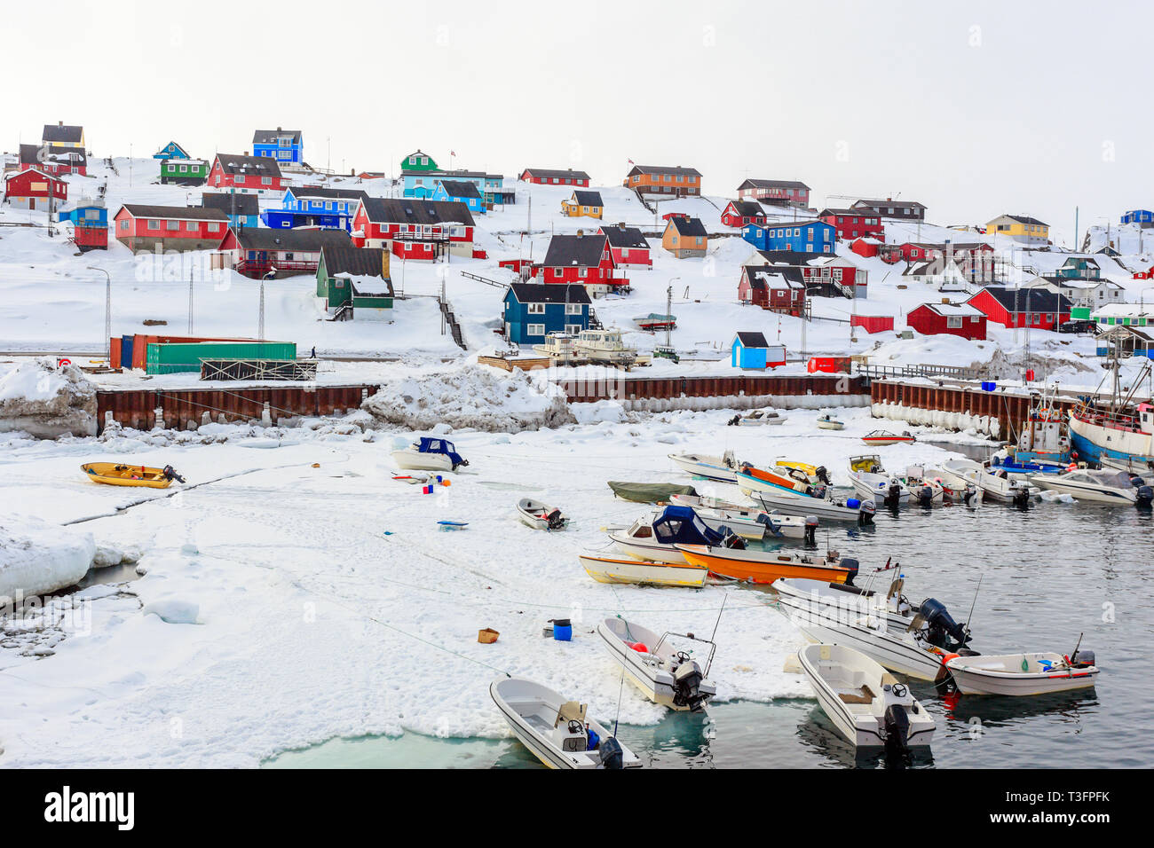 L'area del porto con le barche a motore e colorate case inuit in sfondi, Aasiaat city Foto Stock