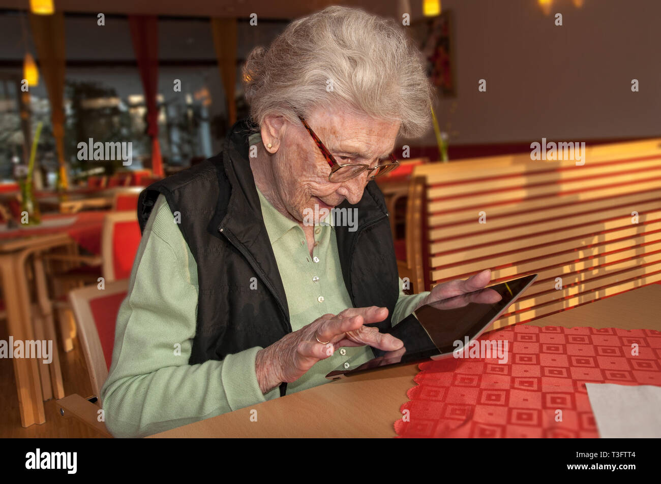 Donna anziana che digita sul computer tablet Foto Stock