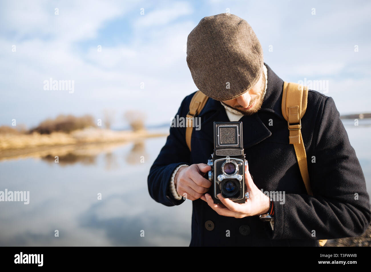 Fotografo con vintage fotocamera. Uomo Barbuto con fotocamera retrò outdoor Foto Stock