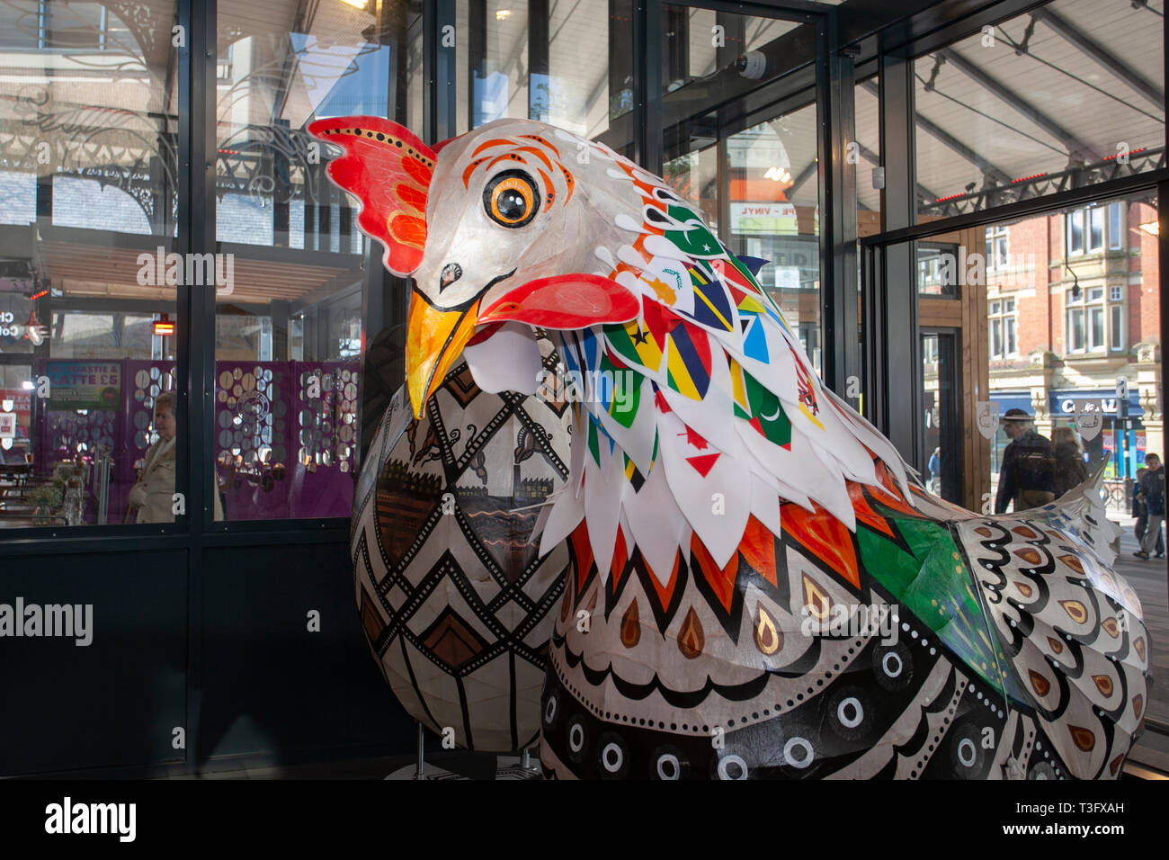 Preston, Lancashire. Regno Unito il 9 aprile 2019. Pasqua gigante di polli sul display nel centro della citta'. Il gigante Papier-Mache galletto di festa di Pasqua cifre sul display. In piedi a due metri di altezza, le attrazioni sono ad essere posto al di fuori del mercato di Preston. Keith Ogden, un artista locale è l'uomo dietro il dipinto a mano attrazione. Le uova sono a tema intorno alla città del patrimonio industriale e Lancashire paesaggi. Preston sono i mercati di esibire il gigante Uova di Pasqua per selfie la competizione per le vacanze di Pasqua. Foto Stock