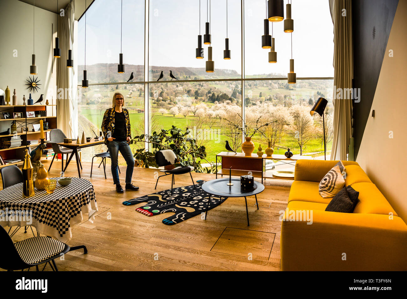 Vista interna dalla casa Vitra. Con una vista sul bellissimo paesaggio e un intero squadrone di granate a mano in aria. Suoni minacciosi? Stiamo parlando della lampada a sospensione progettata da Alvar Aalto per Artek nel 1952. Il suo aspetto semplice ricorda il design industriale e gli si è guadagnato il nome di mano Grenade. Nei tempi della Guerra fredda uno non era apparentemente così sensibile con i soprannomi. Vitra Campus a Weil am Rhein, Germania Foto Stock