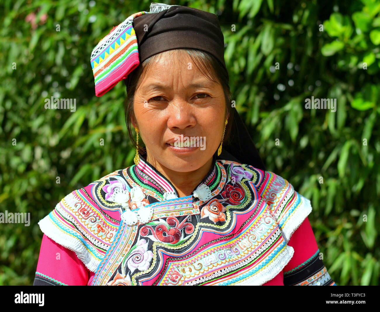 Coppia Miao donna (Cinese minoranza etnica) indossa un colorato tradizionale etnica costume e sorrisi per la fotocamera. Foto Stock