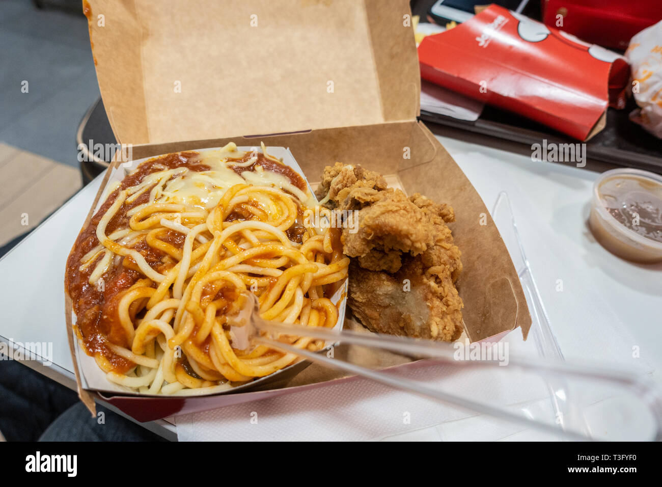 Spaghetti bolognese e il pollo fritto a th eJollibee un ristorante fast food in Earls Court, Londra, Regno Unito Foto Stock