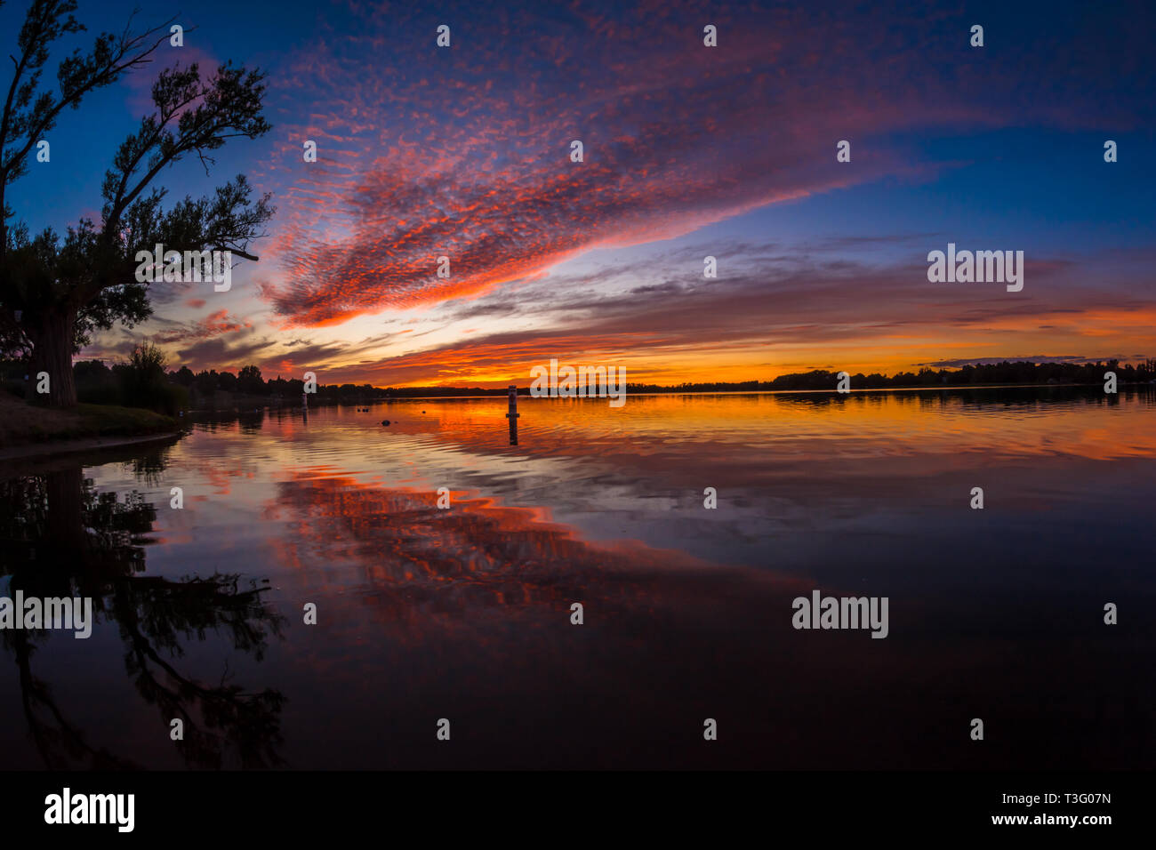 Bungalow LAGO tramonto con splendida rosa,blu,magenta e cielo arancione su un giorno windless Foto Stock