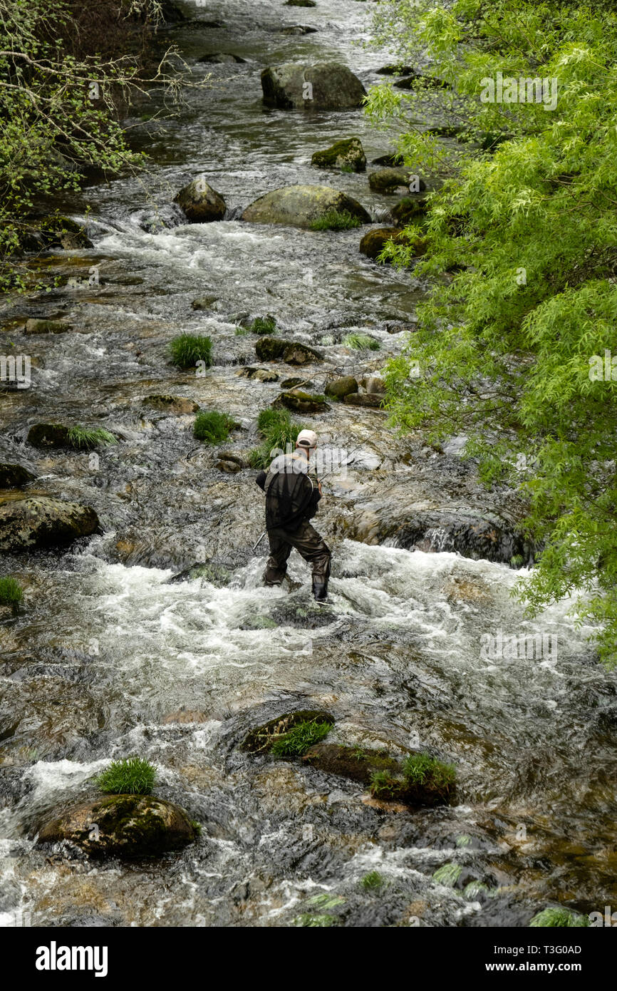 Vista aerea di un pescatore che indossa waders durante la loro attività di pesca all'interno di un fiume Foto Stock