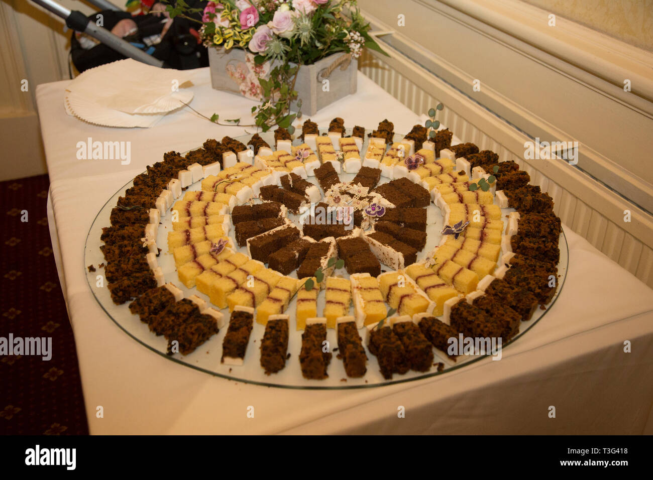 Torta di Nozze tagliati a fettine e collocato in un modello circolare, pronta per essere servita agli ospiti al ricevimento di nozze il giorno delle nozze Foto Stock