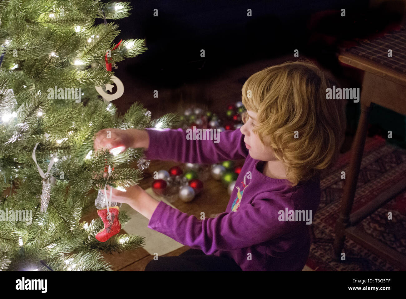 Un otto-anno-vecchia ragazza decora un albero di Natale in Littleton, Massachusetts, STATI UNITI D'AMERICA. Foto Stock