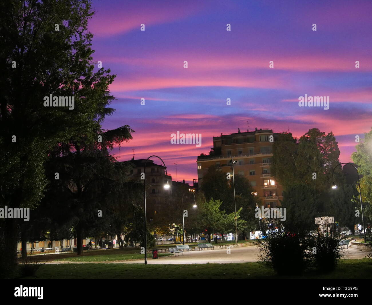 Parco e costruire durante la serata con rosso e bluse sky Foto Stock