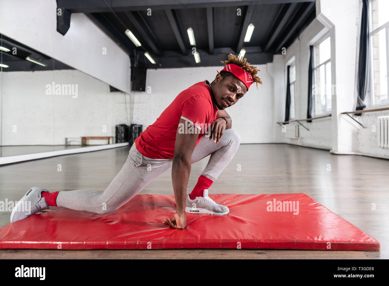 Forte America africana giovane ragazzo stretching i muscoli e le articolazioni Foto Stock