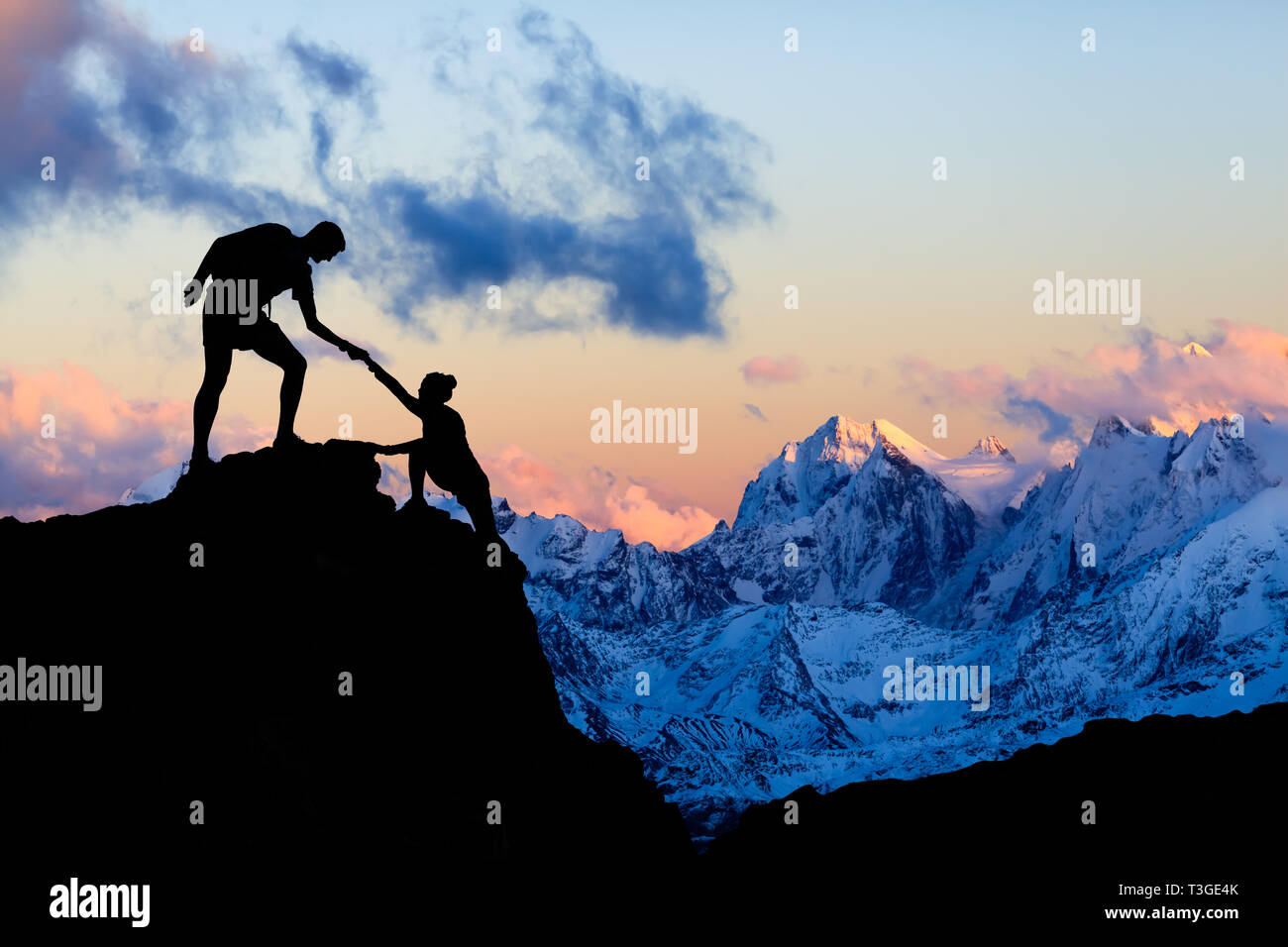 Il lavoro di squadra giovane mano, fiducia nelle montagne. Team di alpinisti l uomo e la donna escursionismo, si aiutano a vicenda sulla cima della montagna, arrampicata insieme, inspir Foto Stock