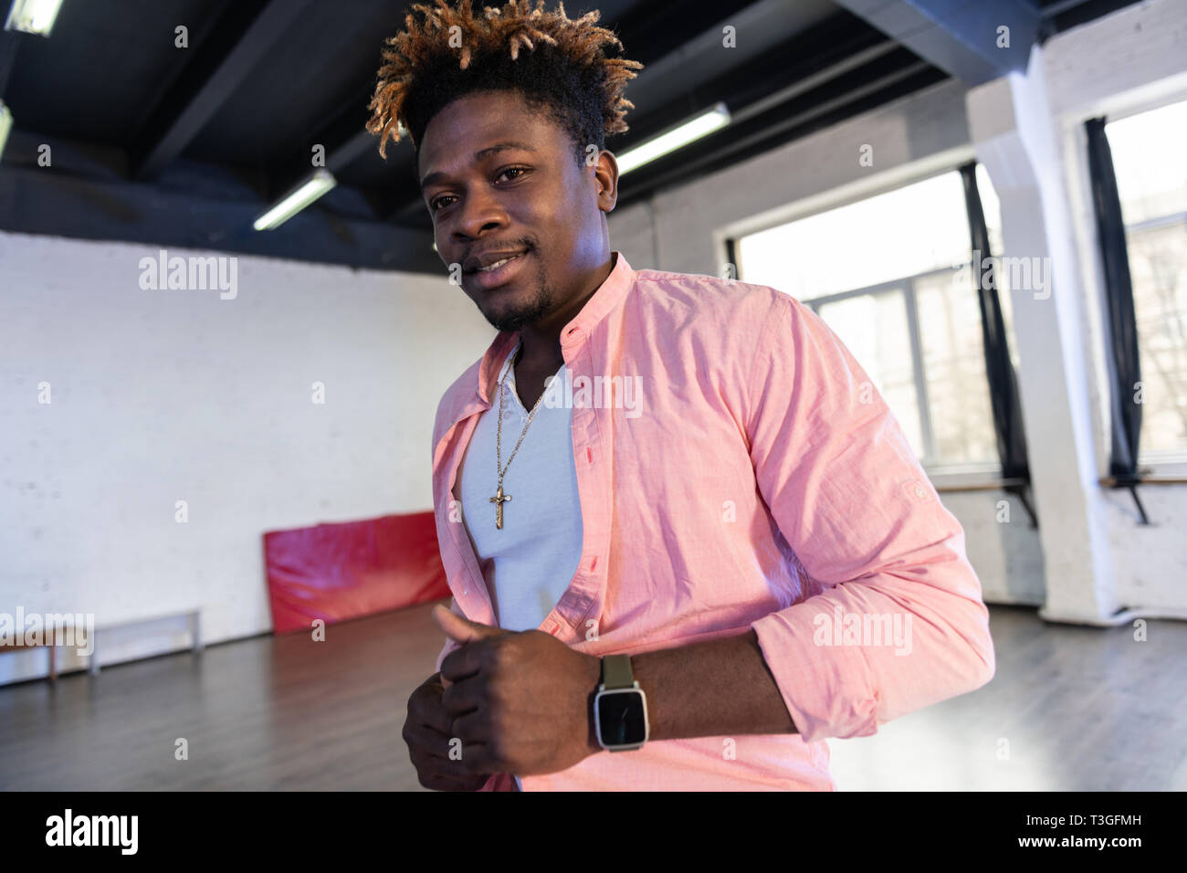 Piacevole a pelo corto americano africano uomo avente orologio elettronico al polso Foto Stock