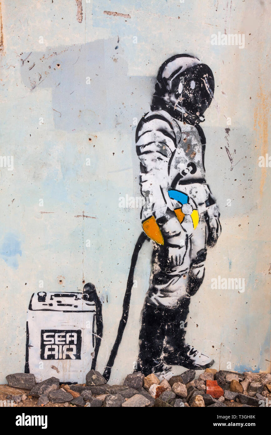 Wall Art Foto di deep sea diver tenendo una palla spiaggia e agganciato a 'sea aria' contenitore a Skinningrove,North Yorkshire Foto Stock