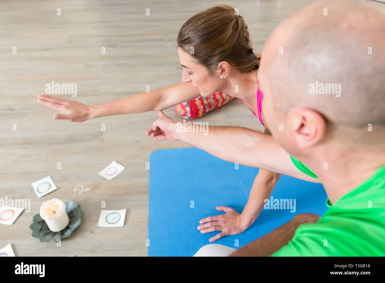 Istruttore aiutare la donna a fare yoga posa Foto Stock