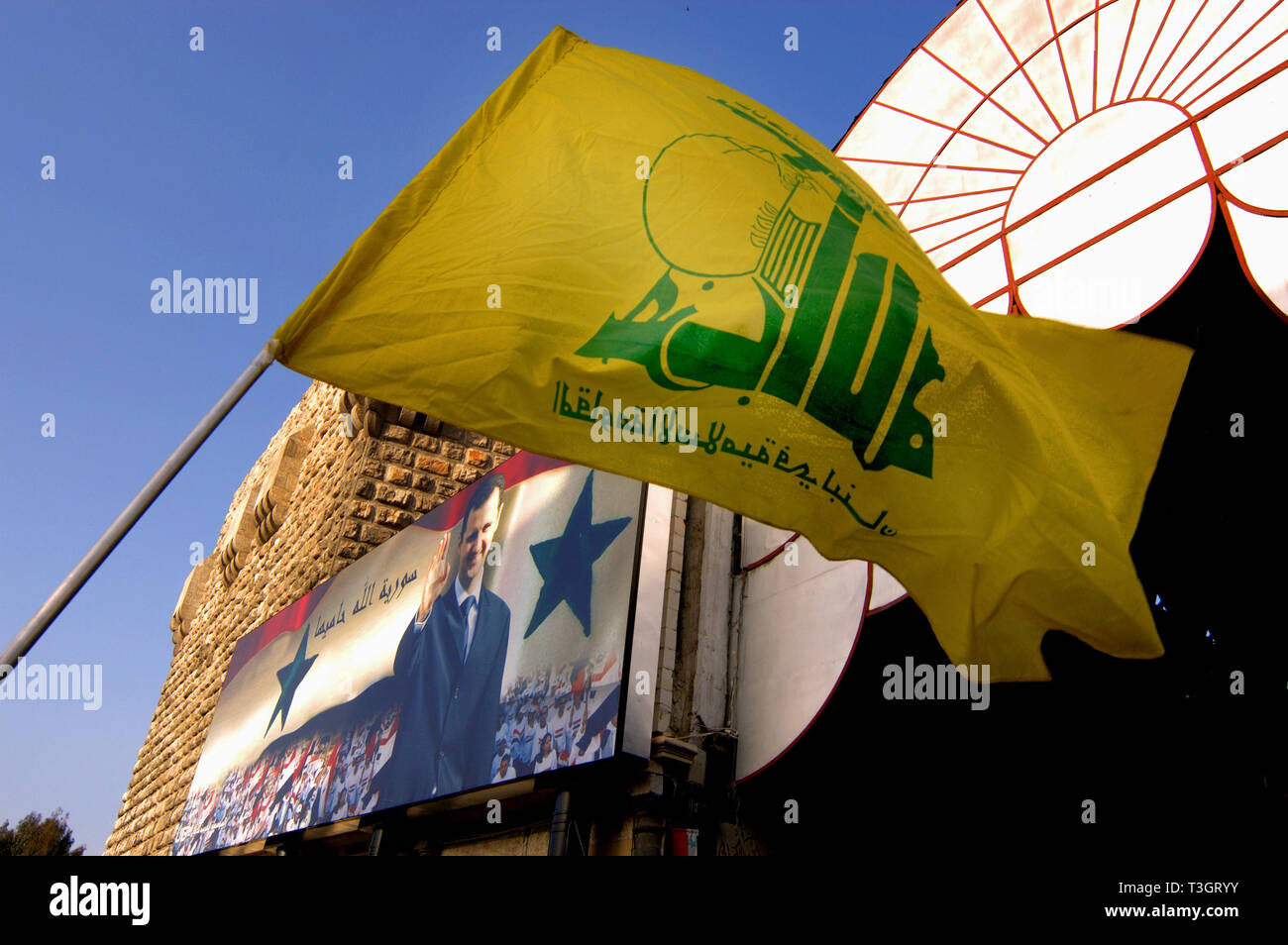 Bandiera di Hezbollah e un poster di Bashar Al Assad a Hamadiyya souk in Damasco, Siria. Foto Stock
