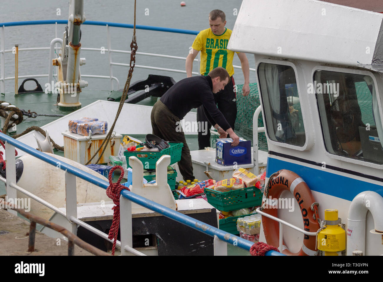 Trawler equipaggio re il provisioning o il ripopolamento di memorizzazione alimentare nave. Foto Stock