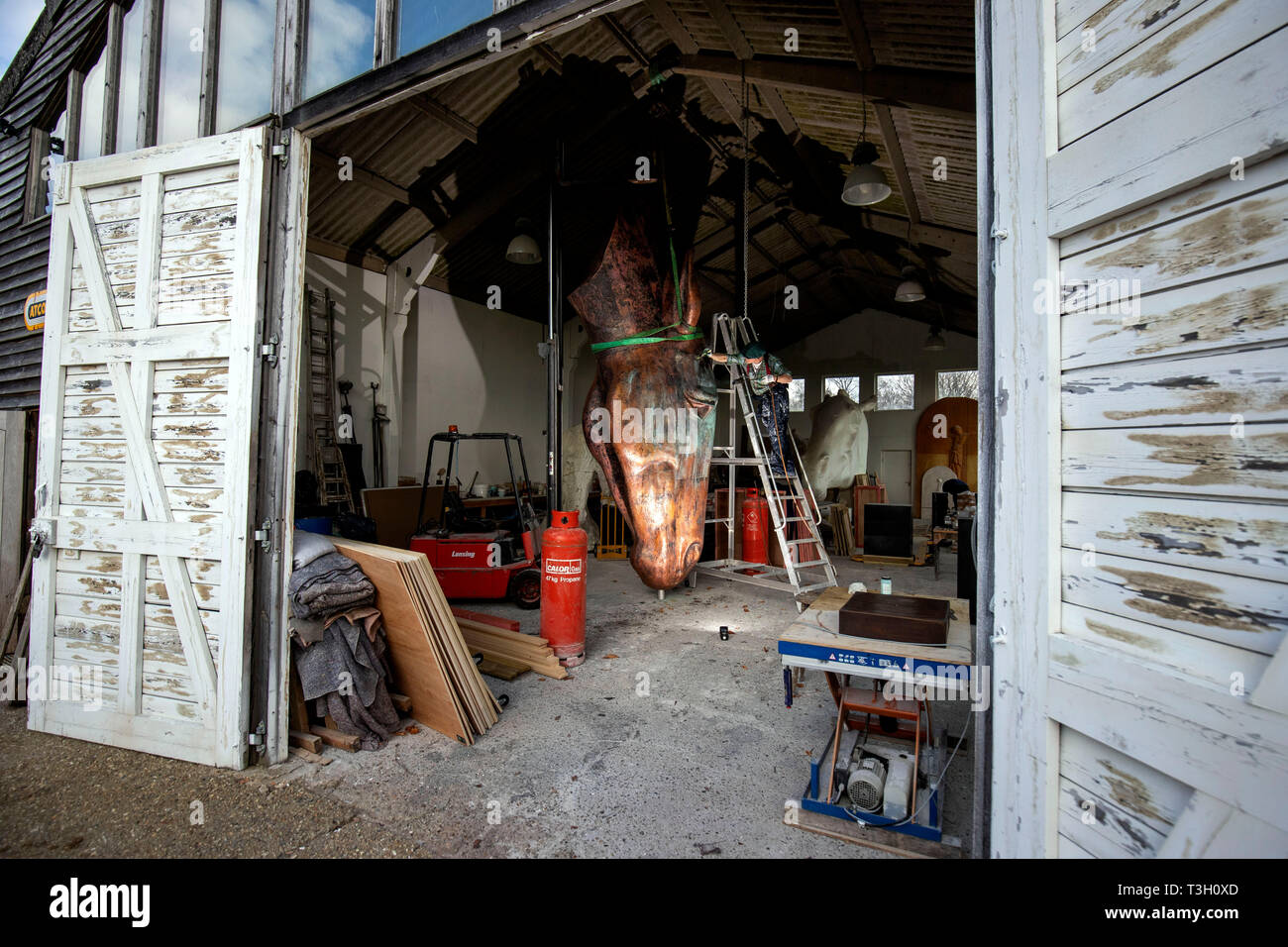 Lo scultore britannico Nic Fiddian-Green mette gli ultimi ritocchi al suo nuovo 6m alto Copper Horse nel suo studio di Surrey, prima di essere trasportati a Venezia in Italia per la Biennale Arte Fiera, che va dal 1 Maggio al 31 luglio. Foto Stock