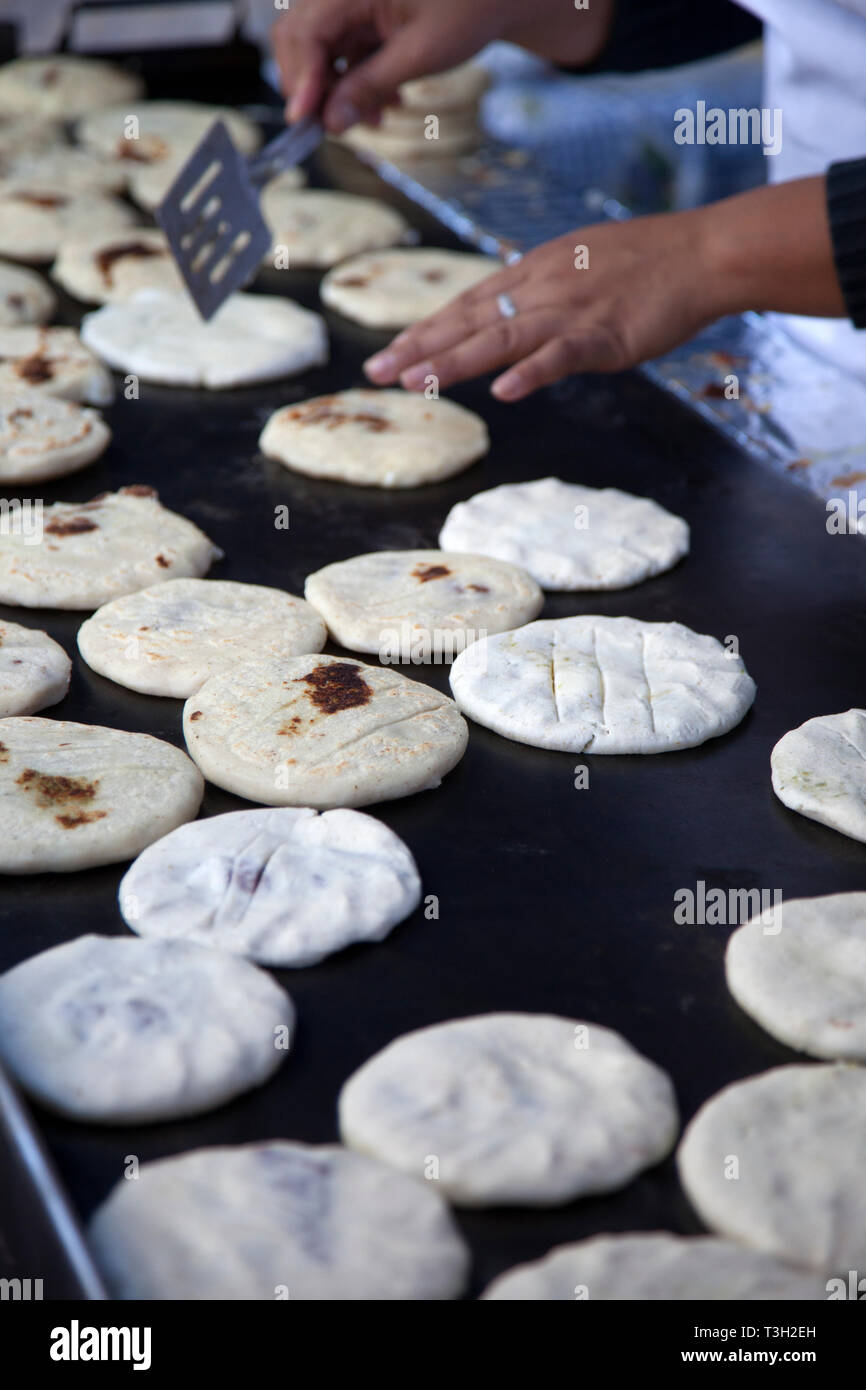 Pupusas, una tipica strada di El Salvador il cibo proveniente da mais, essendo cotti su una strada laterale comal in El Salvador, Foto Stock