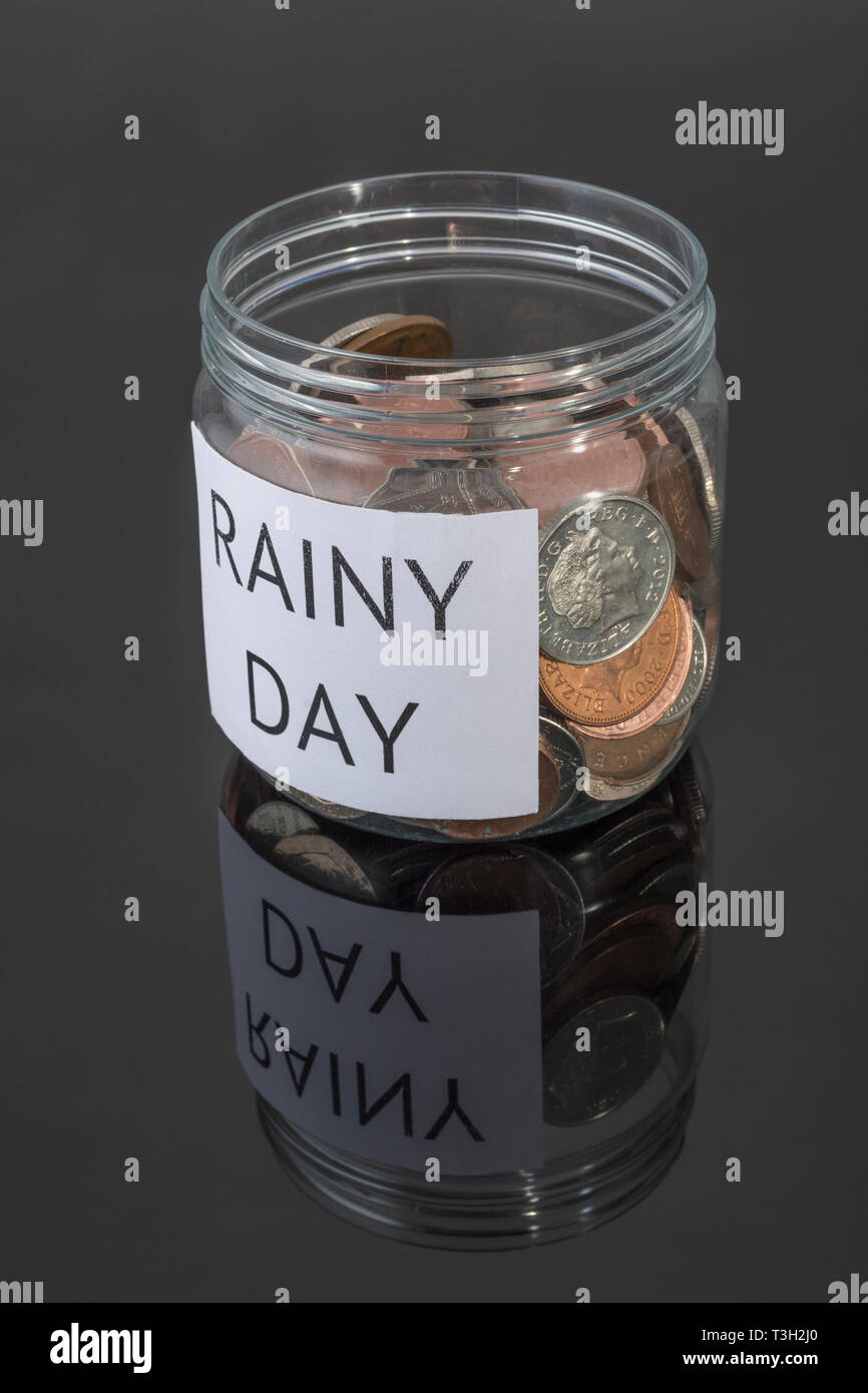 Contenitore di plastica contenente le monete del Regno Unito. Metafora risparmi personali, Rainy day risparmio, risparmi pensionistici pot, Risparmi pensione, il risparmio per il pensionamento . Foto Stock