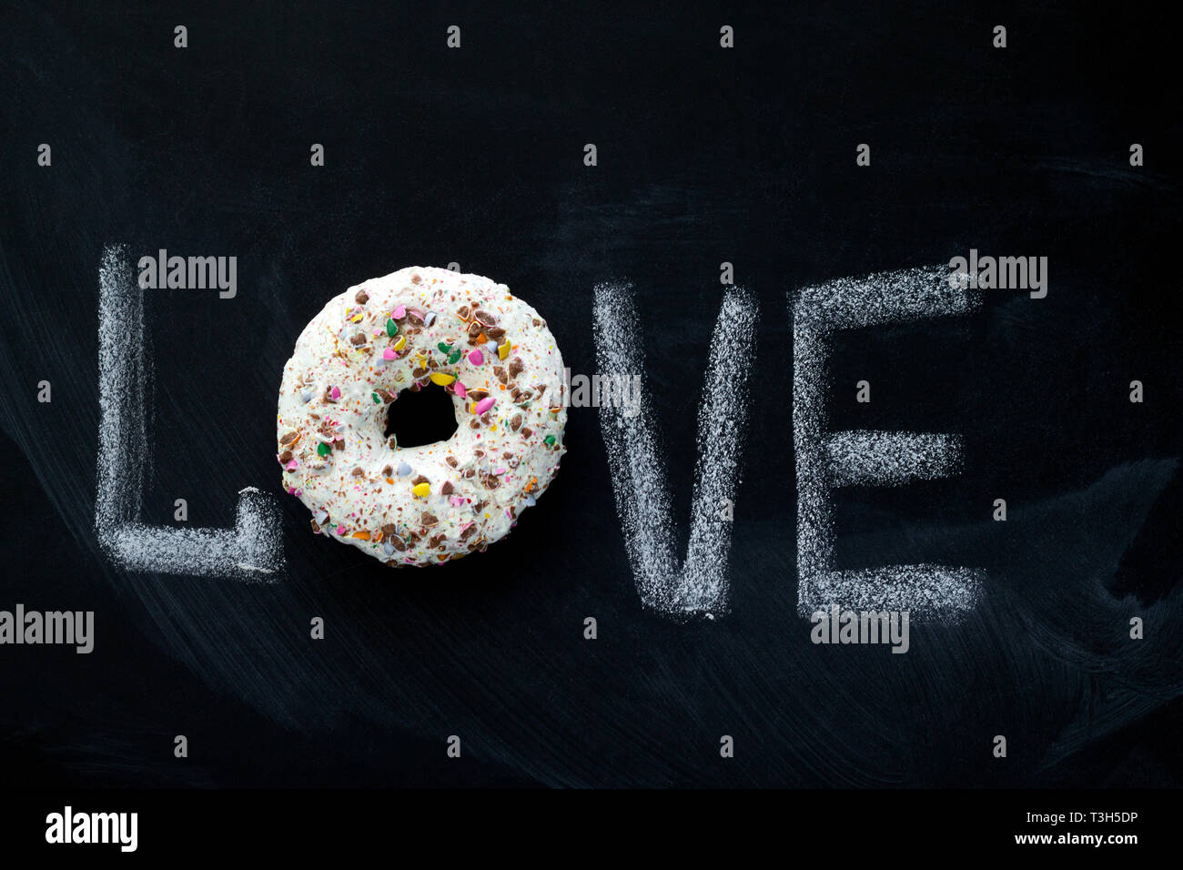 Iscrizione di amore su una scheda di gesso e smalto dolce ciambella vista superiore Foto Stock