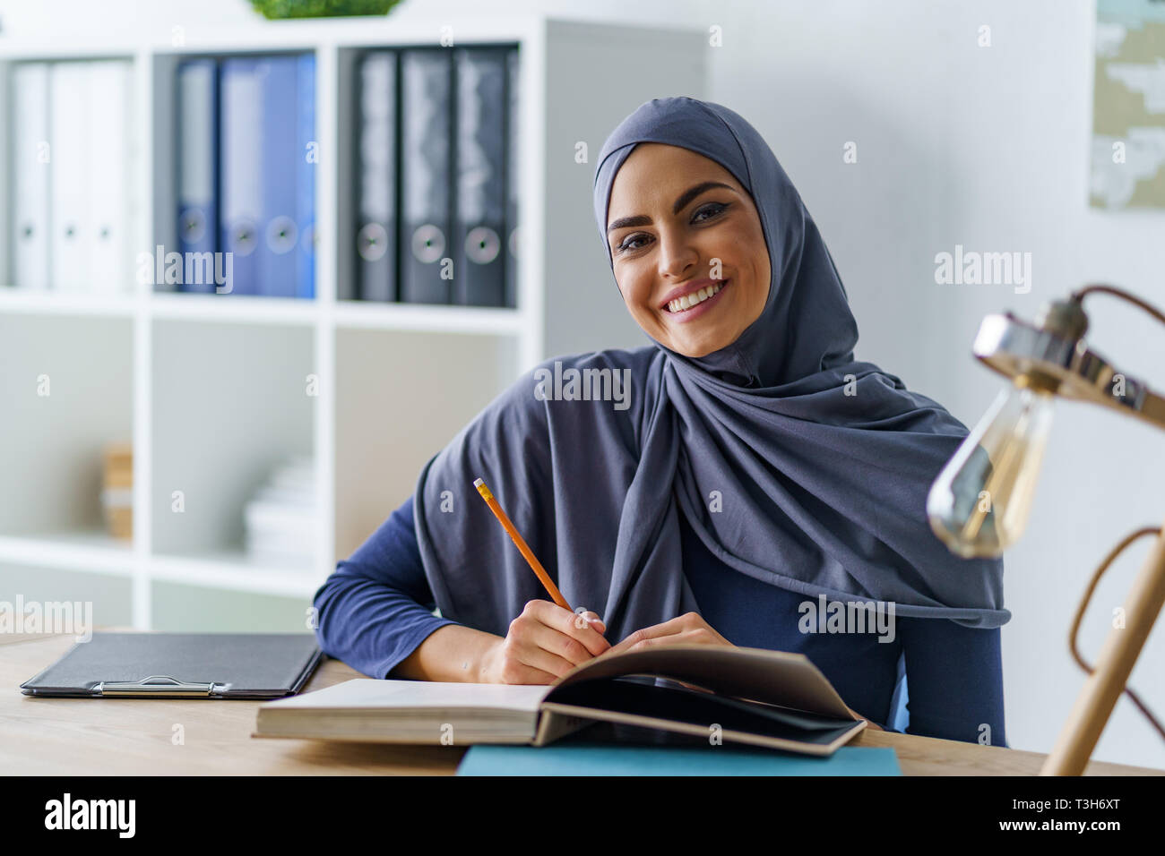 Sorridente Arabian donna seduta Foto Stock