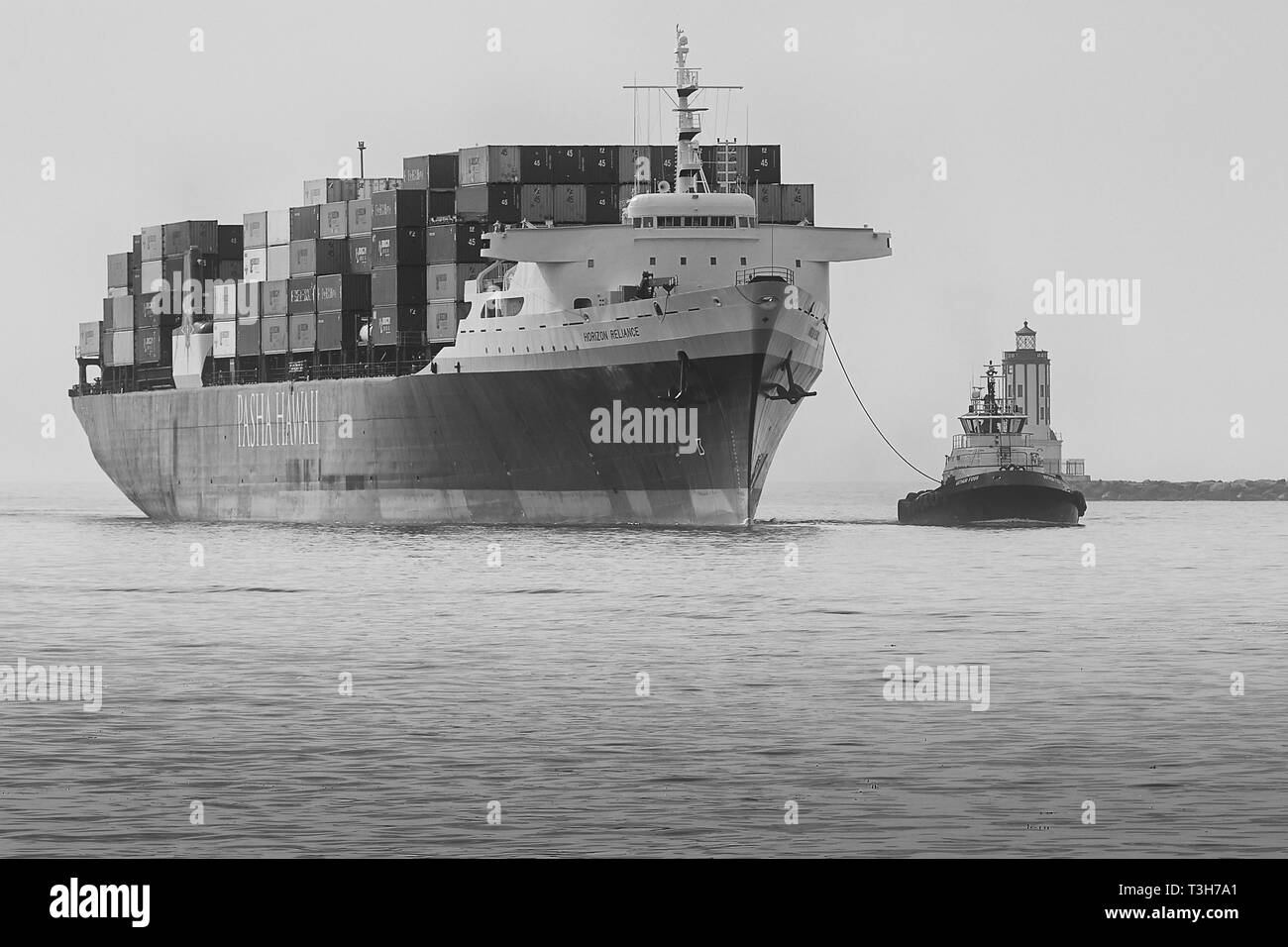 Foto in bianco e nero della nave container PASHA HAWAII, HORIZON RELIANCE, che entra nel canale principale di Los Angeles presso il faro Angels Gate, USA Foto Stock