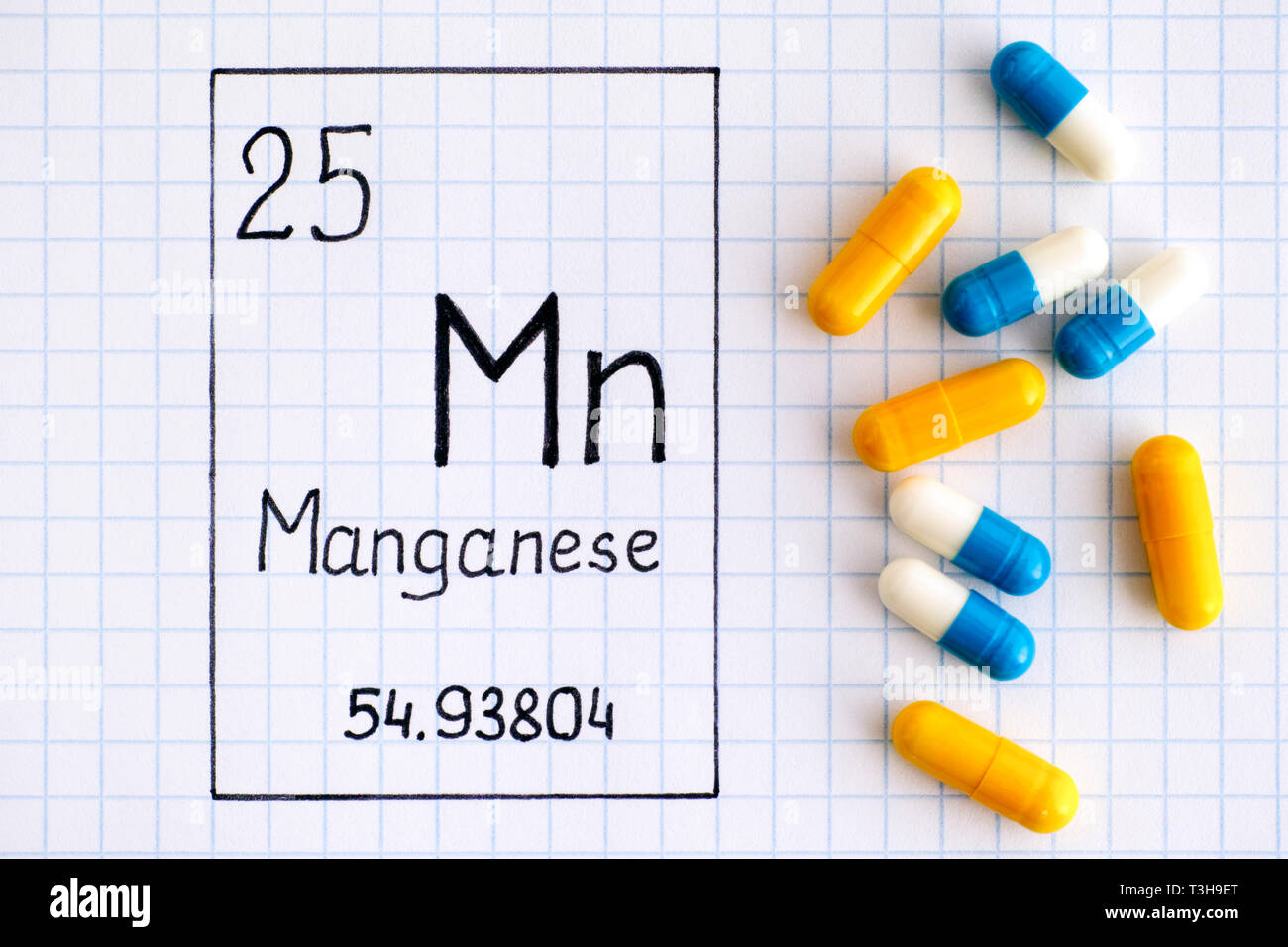 La grafia elemento chimico manganese Mn con alcune pillole. Close-up. Foto Stock
