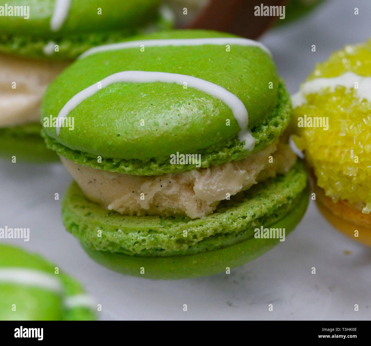 Green macarons hor' d'oeuvres riempito con gelato alla vaniglia sul cristallo piatto di vetro Foto Stock