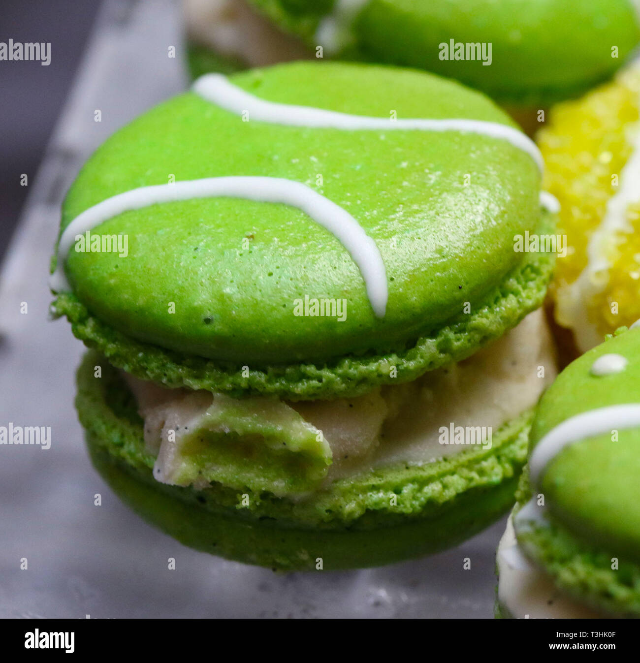 Green macarons hor' d'oeuvres riempito con gelato alla vaniglia sul cristallo piatto di vetro Foto Stock