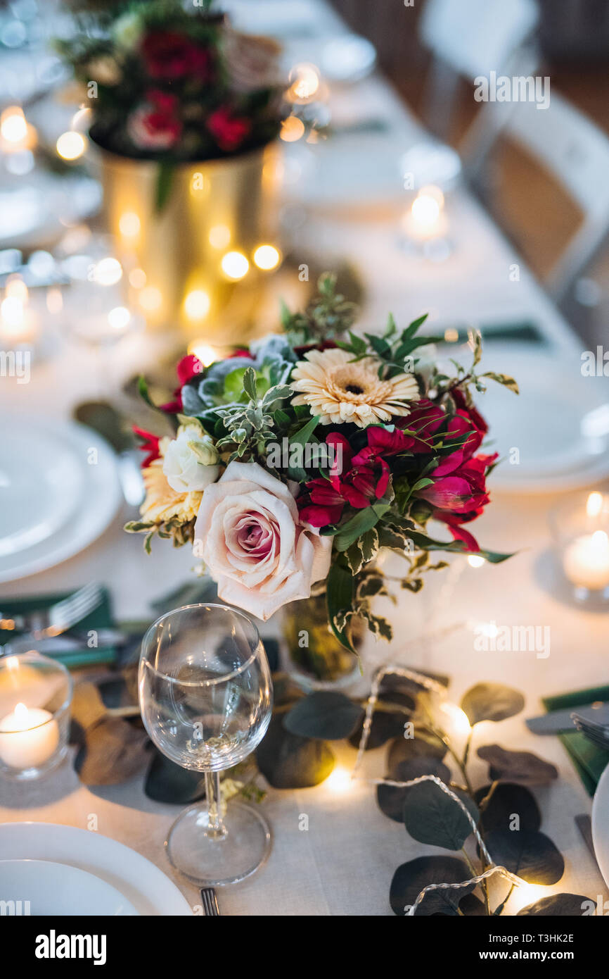 Tabella impostata per un pasto al chiuso in una stanza su un party, un matrimonio o una famiglia celebrazione. Foto Stock