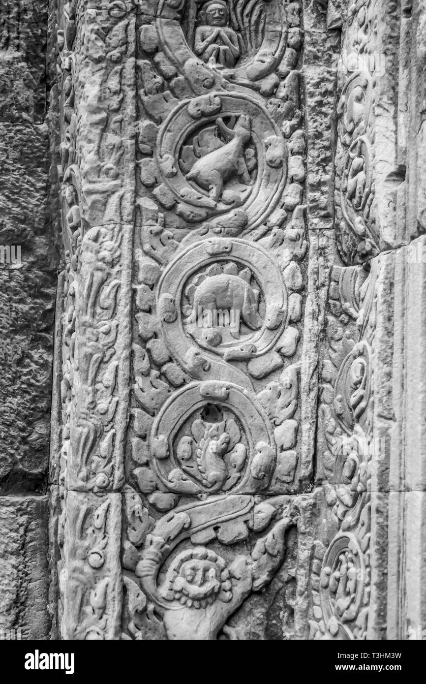 Pannello di animale, compreso il famigerato dinosauro nelle rovine di pietra di Ta Prohm, o il Tempio della giungla, in Siem Reap, Cambogia in B&W. Foto Stock