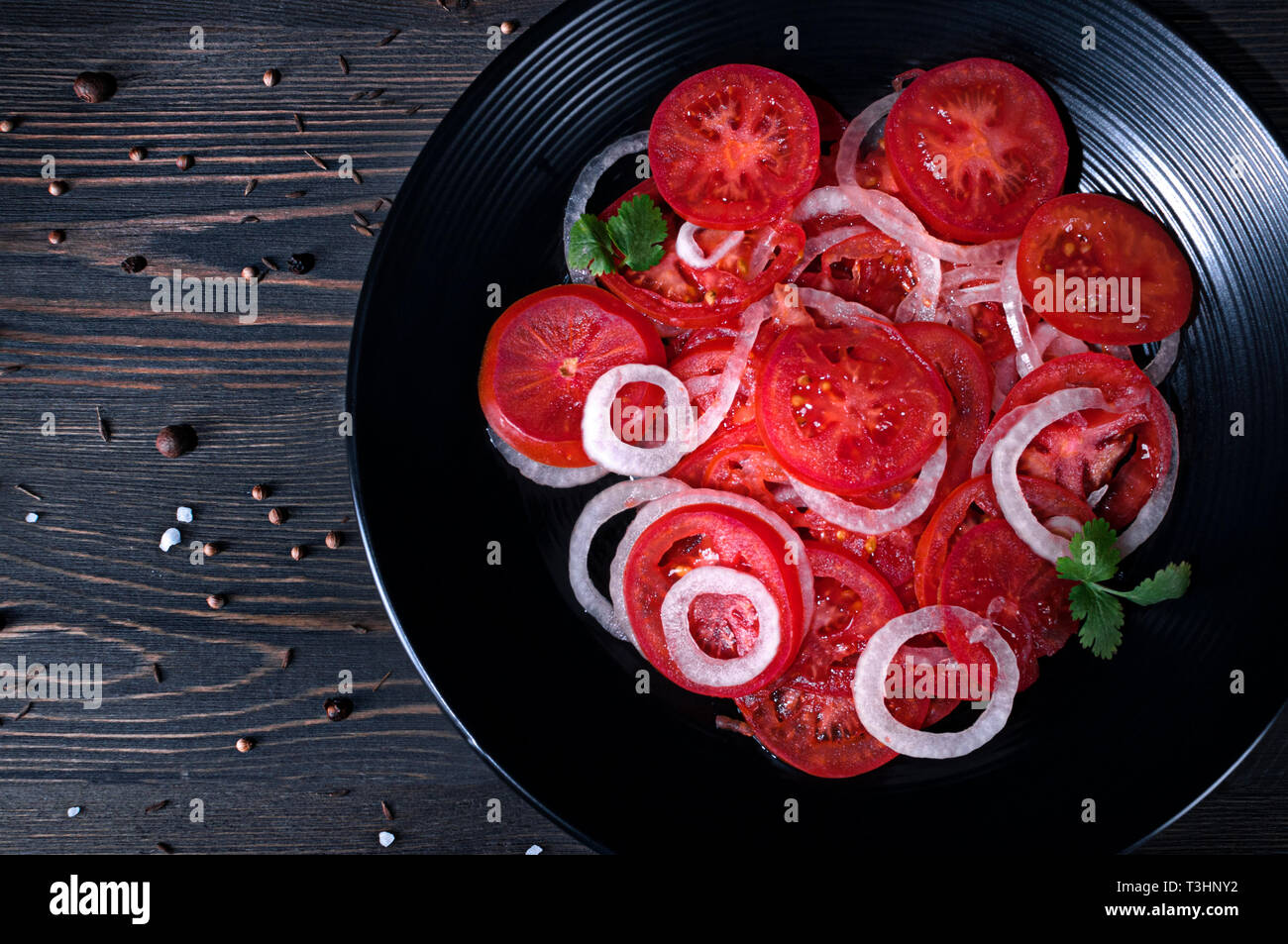 Deliziosa e succosa insalata di pomodoro con le cipolle e le erbe aromatiche. La primavera e l'estate i pasti. Foto Stock