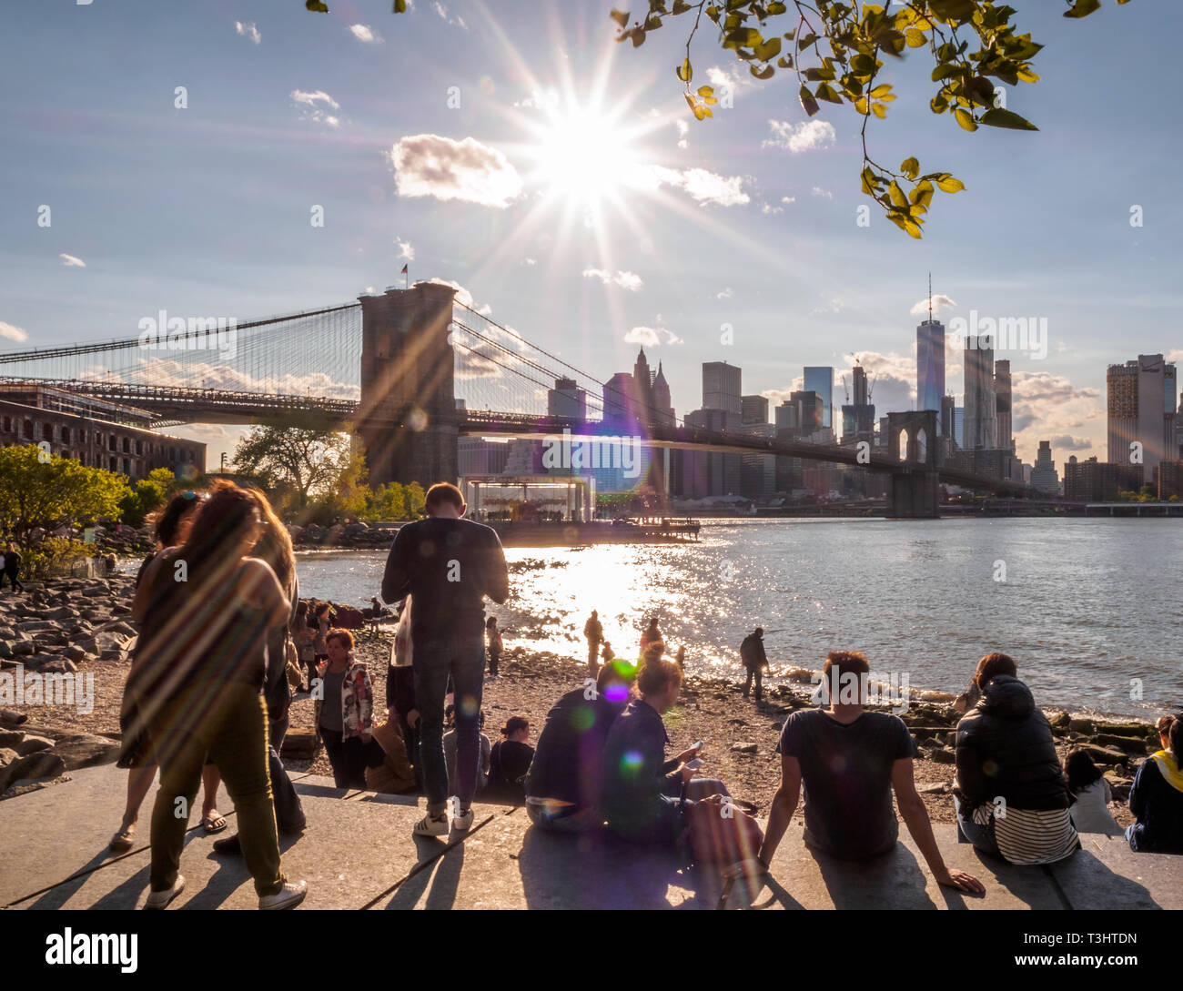 Turisti e locali simili relax su una pigra giornata di sole mentre guardando il ponte di Brooklyn e new york skyline della città Foto Stock