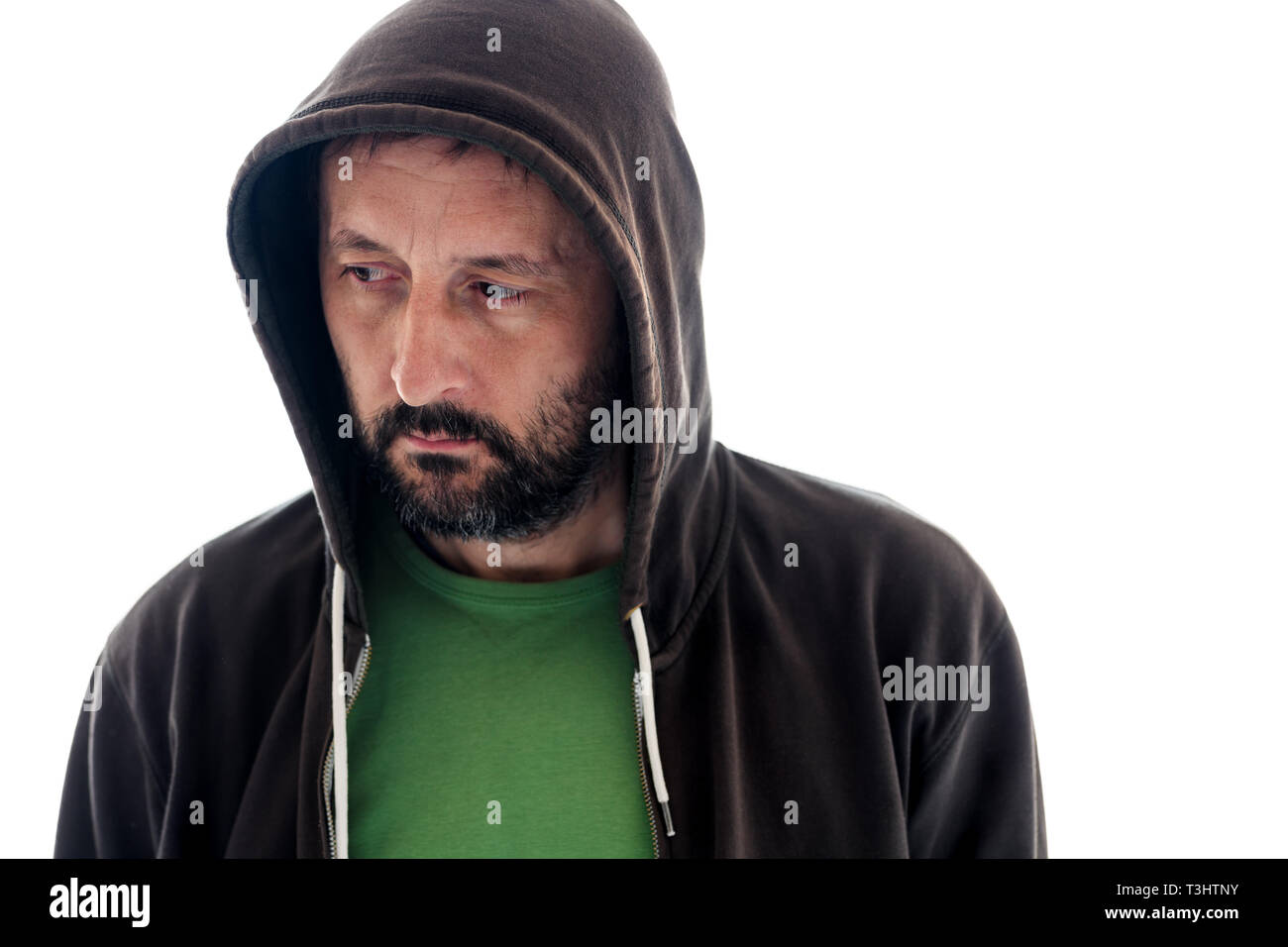 Deluso l'uomo con la felpa con cappuccio isolato su sfondo bianco guardando verso il basso e da un lato, evitando il contatto con gli occhi Foto Stock