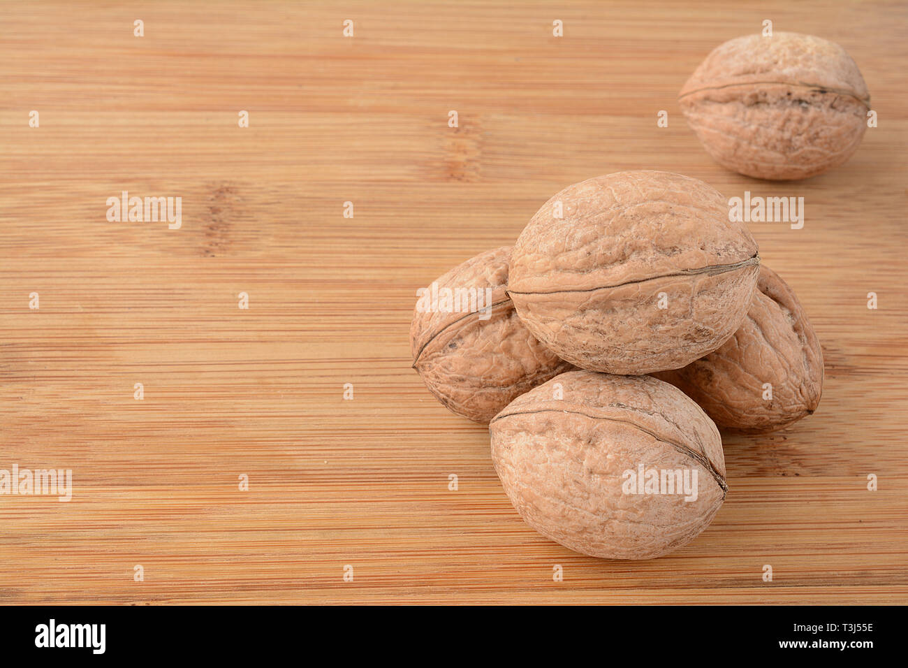 Cumulo di wallnuts su sfondo di legno con copia spazio, vista ravvicinata Foto Stock